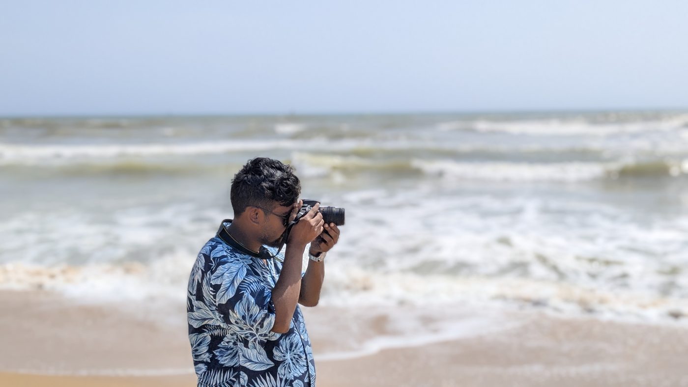 Nahid taking a photograph by the sea